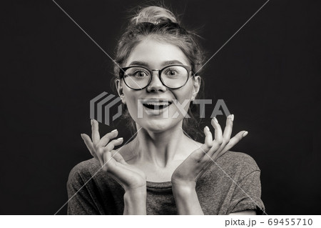 Surprised happy blonde woman rejoices isolated camera over black background 69455710