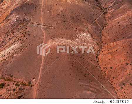 Aerial shot of the textured yellow nad red mountains resembling the surface of Mars Aerial shot of the textured yellow nad red mountains resembling the surface of Mars 69457316