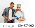 Father and son reviewing their vacation pictures 69457492