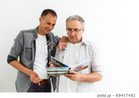 Father and son reviewing their vacation pictures Father and son reviewing their vacation pictures 69457492