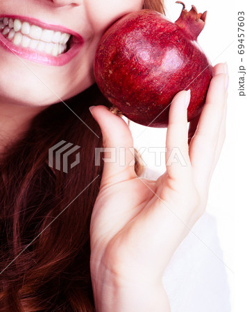 Cheerful woman holds pomegranate fruits Cheerful woman holds pomegranate fruits 69457603