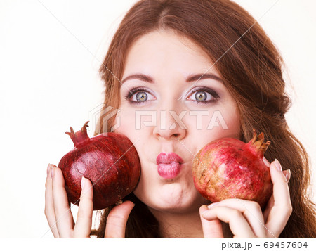 Joyful girl playing with pomegranate fruits Joyful girl playing with pomegranate fruits 69457604