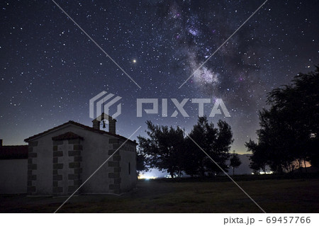 Starry night with the Milky Way over a small church 69457766