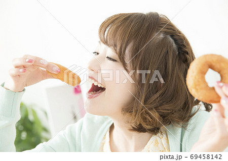 ドーナツを食べる女性 69458142