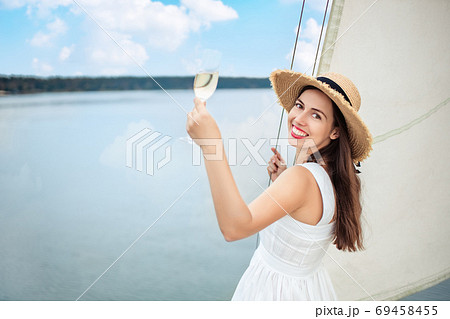 woman with glass of champagne resting on boat 69458455