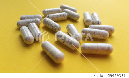 White pill capsules on yellow background. Simple flat lay with pastel texture. Medical concept. Stock photo. White pill capsules on yellow background. Simple flat lay with pastel texture. Medical concept. Stock photo. 69459381