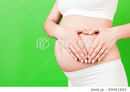Cropped image of pregnant woman in white underwear holding her h Cropped image of pregnant woman in white underwear holding her h 69461605