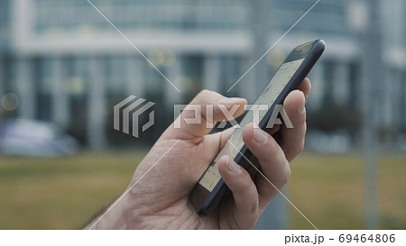 Hands using a mobile phone to check stock market data 69464806