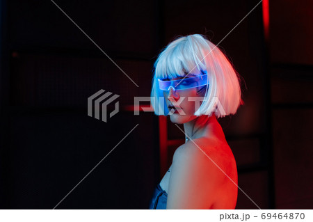 Blonde in cyberpunk style. Futuristic glasses on a woman. 69464870