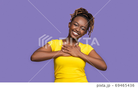 Thankful smiling african girl holding hands on her chest 69465436