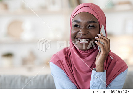 Phone Call. Black Muslim Girl In Hijab Talking On Cellphone At Home 69465583