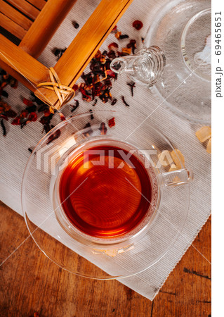 Cup of hot tea with rock sugar, dry tea leaves served in thermo glass tea cup Cup of hot tea with rock sugar, dry tea leaves served in thermo glass tea cup 69465651