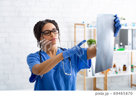 Thoughtful radiologist looking at animal xray in veterinarian hospital Thoughtful radiologist looking at animal xray in veterinarian hospital 69465870