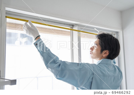 部屋の間取りの採寸をする日本人男性作業員 69466292
