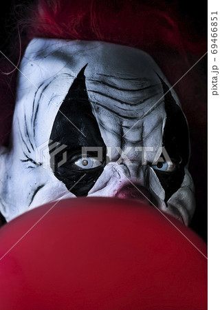 scary evil clown with a red balloon 69466851