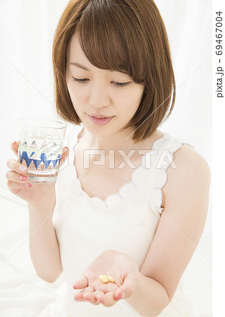 サプリメントを飲む女性 69467004