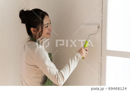 DIYで家の壁にペンキを塗る女性 DIYで家の壁にペンキを塗る女性 69468124