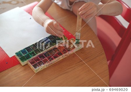 Three year old boy paint with watercolor at home.  69469020