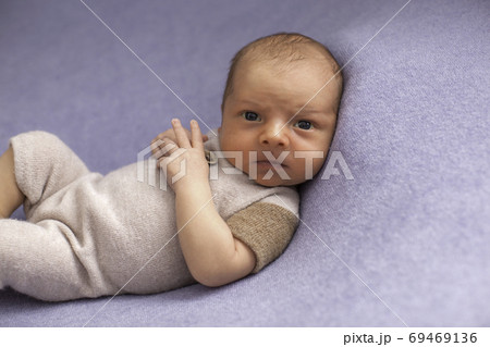 Newborn baby boy on blue textile background.  69469136