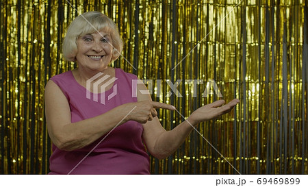 Senior old woman pointing empty place on her palm, copy space advertising area on hand 69469899