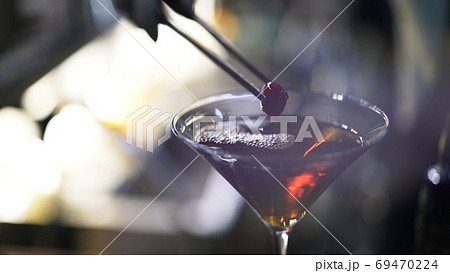 Cocktail glass and garnish, red berry, close up macro shot Cocktail glass and garnish, red berry, close up macro shot 69470224