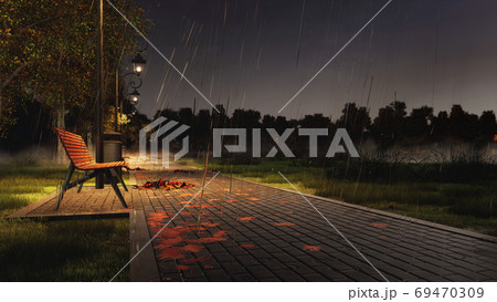Empty bench on park walkway at rainy autumn night 69470309
