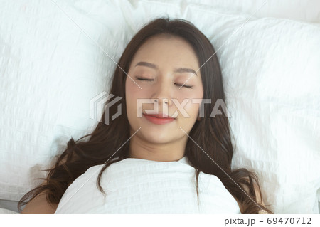 Asian women sleeping and sweet dream on white bed in bedroom Asian women sleeping and sweet dream on white bed in bedroom 69470712
