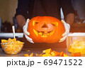 man cutting a jack-o-lantern pumpkin to halloween celebration. 69471522