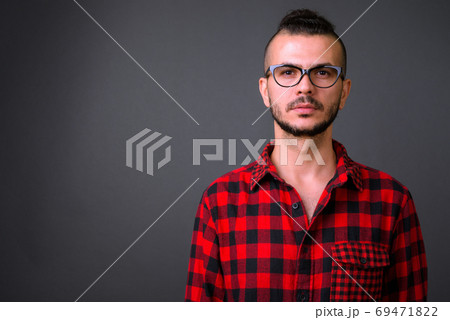 Face of handsome bearded Turkish hipster man with eyeglasses 69471822