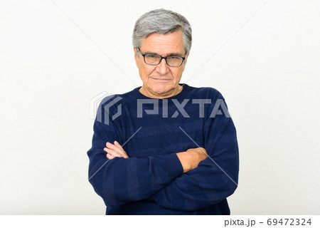 Portrait of handsome senior man wearing eyeglasses with arms crossed Portrait of handsome senior man wearing eyeglasses with arms crossed 69472324
