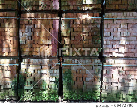 Pallet of clay brick that has been abandoned and overgrown by moss Pallet of clay brick that has been abandoned and overgrown by moss 69472796