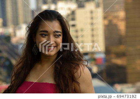 Happy young beautiful Indian woman thinking in the city 69473192