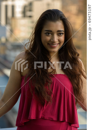 Happy young beautiful Indian woman smiling in the city Happy young beautiful Indian woman smiling in the city 69473197