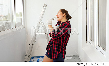 positive lady sings using brush as microphone on terrace 69473849