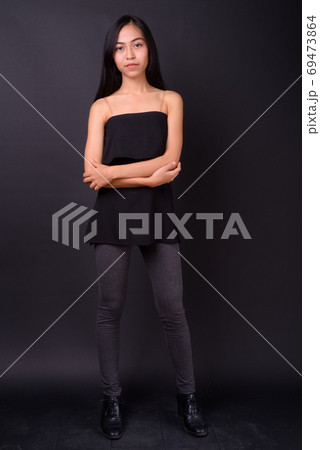 Full body shot of young beautiful Asian woman with arms crossed 69473864