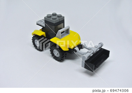 Toy Bulldozer made from yellow and black plastic bricks and with wheels isolated on a white background. Toy Bulldozer made from yellow and black plastic bricks and with wheels isolated on a white background. 69474306