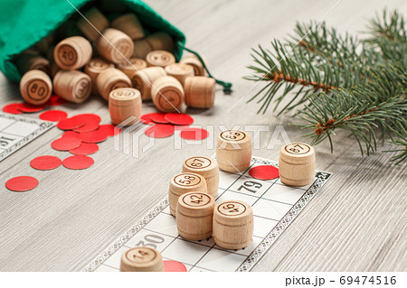 Wooden lotto barrels with bag, game cards and red chips for a game in lotto Wooden lotto barrels with bag, game cards and red chips for a game in lotto 69474516