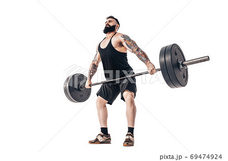 The technique of doing an exercise of deadlift with a barbell of a muscular strong tattooed bearded sports men on a white studio background. Isolate The technique of doing an exercise of deadlift with a barbell of a muscular strong tattooed bearded sports men on a white studio background. Isolate 69474924