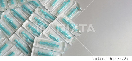 Medical syringes in a package. A bunch of unused, packaged syringes. 69475227