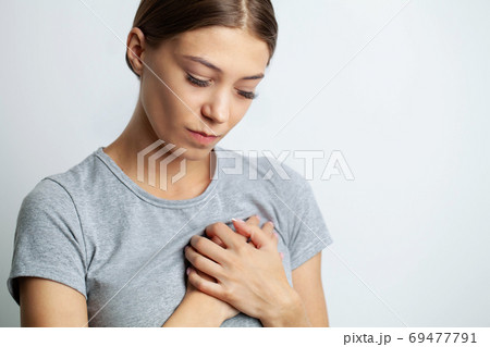 Young woman in pajamas having heart attack 69477791