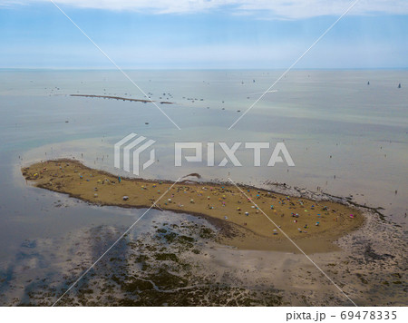 Aerial view of unidentifiable people enjoying a sandbank at the beach of Grado in the province of Gorizia at the Northern Adriatic Sea 69478335