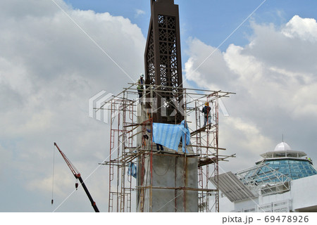 KUALA LUMPUR, MALAYSIA -MAY 05, 2016: Construction workers wearing a safety harness and adequate safety gear when climbing the scaffolding. This is to ensure their safety while working at a high level 69478926
