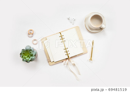 Minimal office desk table with stationery set, coffee cup, earphone and green plant in a pot. Minimal office desk table with stationery set, coffee cup, earphone and green plant in a pot. 69481519