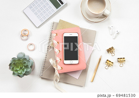 Minimal office desk table with stationery set, coffee cup, earphone and green plant in a pot. Minimal office desk table with stationery set, coffee cup, earphone and green plant in a pot. 69481530