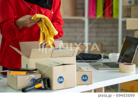 Online seller works at home office and packs shipping delivery box to customer. 69483899