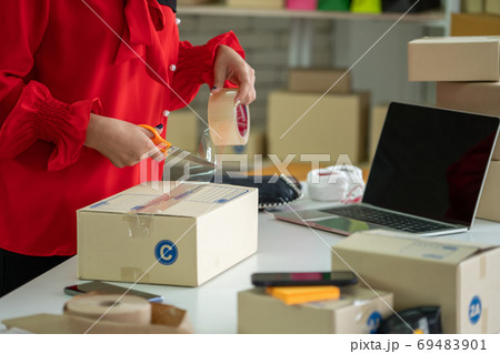 Online seller works at home office and packs shipping delivery box to customer. 69483901