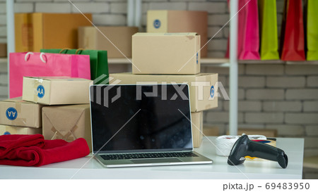 Laptop computer empty screen with shipping box in background Laptop computer empty screen with shipping box in background 69483950