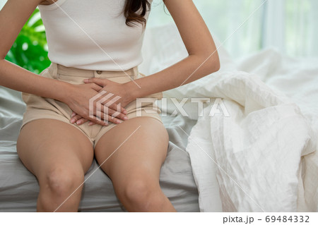 woman have bladder pain and stomach ache sitting on bed in bedroom after wake up feeling so sick and painful,Healthcare concept 69484332