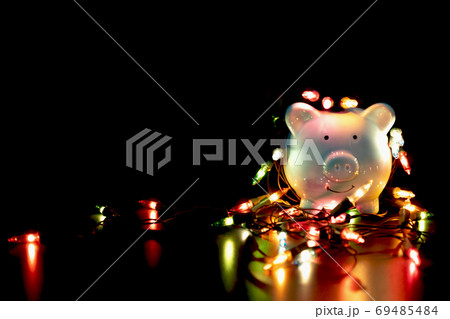 Blue piggy bank with Christmas string lights on happy December festival Blue piggy bank with Christmas string lights on happy December festival 69485484