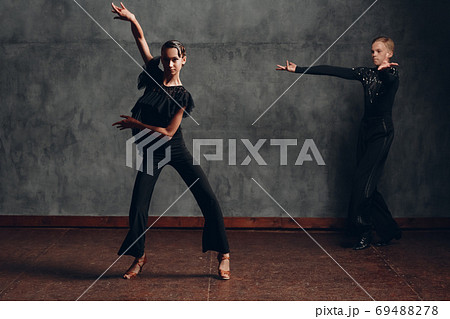 Young couple dancing in ballroom dance cha-cha-cha. 69488278